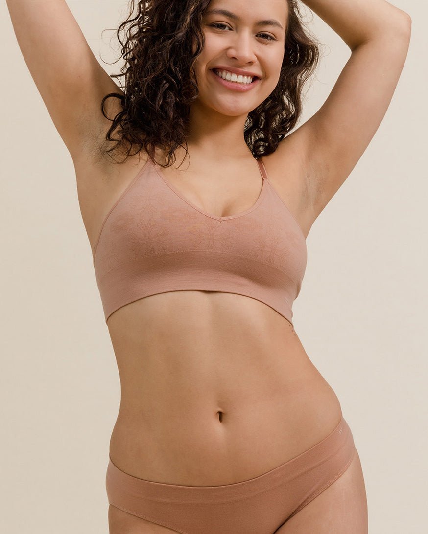 Woman wearing BRANWYN's Essential Bralette, a bra from the Essential Collection. Made from soft, moisture-wicking Merino wool using seamless technology, this performance innerwear provides performance, comfort, and sustainability. The fabric is free from BPA, PFAS, and forever chemicals.