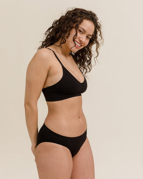 Woman wearing BRANWYN's Essential Bralette, a bra from the Essential Collection. Made from soft, moisture-wicking Merino wool using seamless technology, this performance innerwear provides performance, comfort, and sustainability. The fabric is free from BPA, PFAS, and forever chemicals.