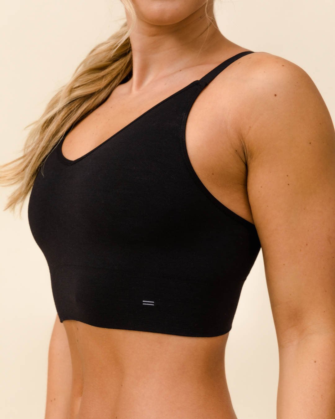 Woman wearing BRANWYN's Essential Busty Bra, a bra from the Essential Collection. Made from soft, moisture-wicking Merino wool using seamless technology, this performance innerwear provides performance, comfort, and sustainability. The fabric is free from BPA, PFAS, and forever chemicals.