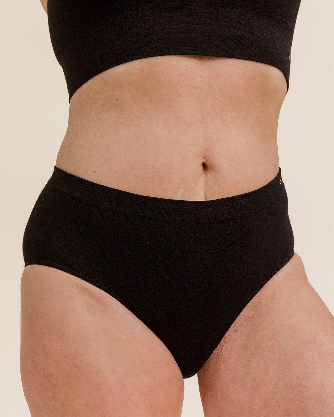 Woman wearing BRANWYN's Essential Hipster, a underwear from the Essential Collection. Made from soft, moisture-wicking Merino wool using seamless technology, this performance innerwear provides performance, comfort, and sustainability. The fabric is free from BPA, PFAS, and forever chemicals.