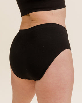 Woman wearing BRANWYN's Essential Hipster, a underwear from the Essential Collection. Made from soft, moisture-wicking Merino wool using seamless technology, this performance innerwear provides performance, comfort, and sustainability. The fabric is free from BPA, PFAS, and forever chemicals.