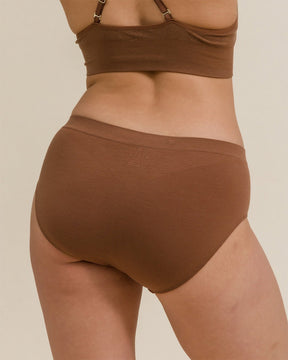 Woman wearing BRANWYN's Essential Hipster, a underwear from the Essential Collection. Made from soft, moisture-wicking Merino wool using seamless technology, this performance innerwear provides performance, comfort, and sustainability. The fabric is free from BPA, PFAS, and forever chemicals.